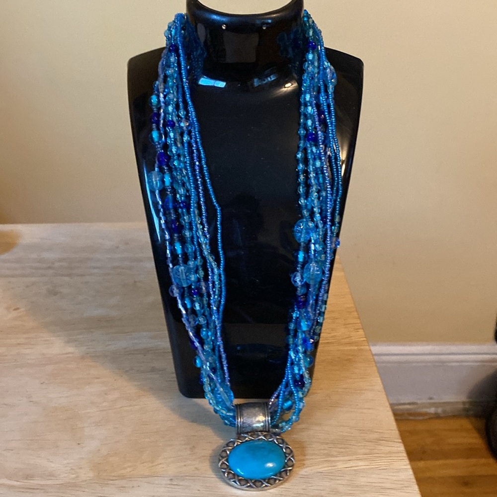 Aqua Blue 8 Beaded strands Necklace with oval aqua blue pendant.